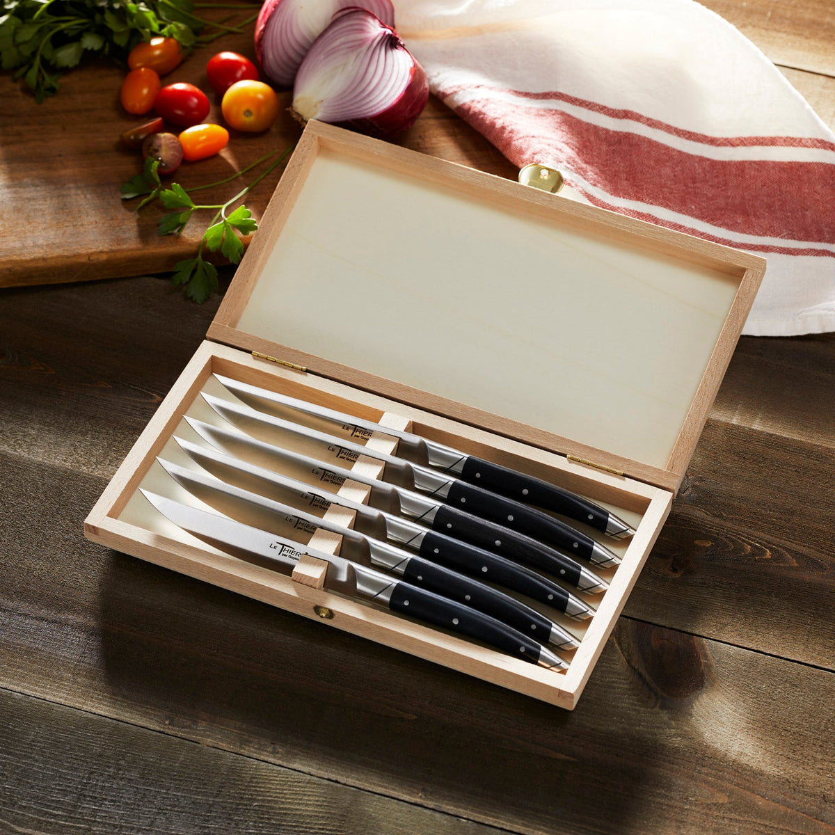 A set of Goyon-Chazeau Black Paperstone Steak Knives Boxed Set/6 in a wooden box.