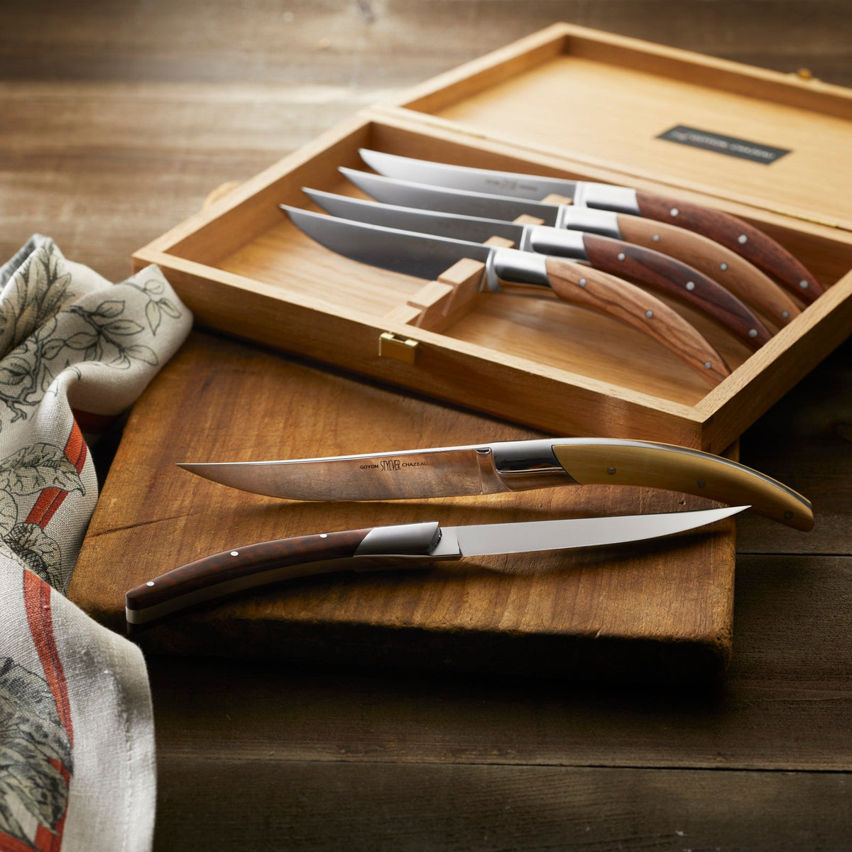 A Goyon-Chazeau Styl&#39;ver Mixed Wood Steak Knives Boxed Set/6 in a wooden box.