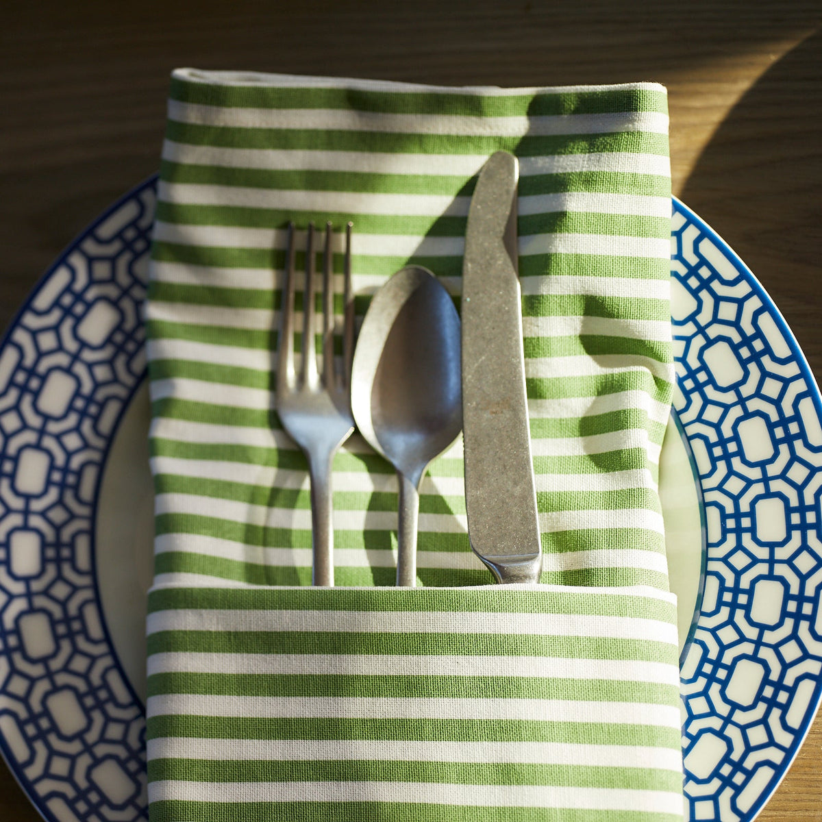 A Caskata Pinstripe Dinner Napkin in spring green.