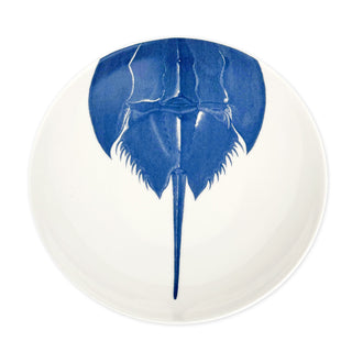 Caskata Artisanal Home's Horseshoe Crab Wide Serving Bowl is crafted from white high-fired porcelain and adorned with a detailed top-view illustration of a blue horseshoe crab.