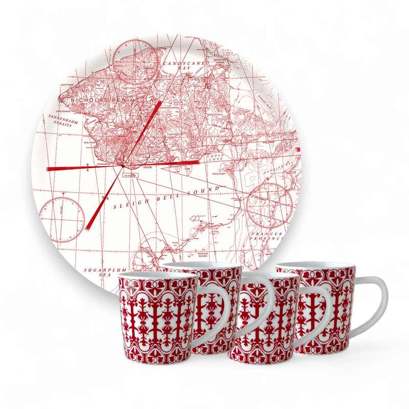 The Caskata "Holiday Cocoa" Bundle features four white porcelain mugs with red geometric patterns, placed in front of a birchwood serving tray adorned with a red vintage map design, all set against a white background.