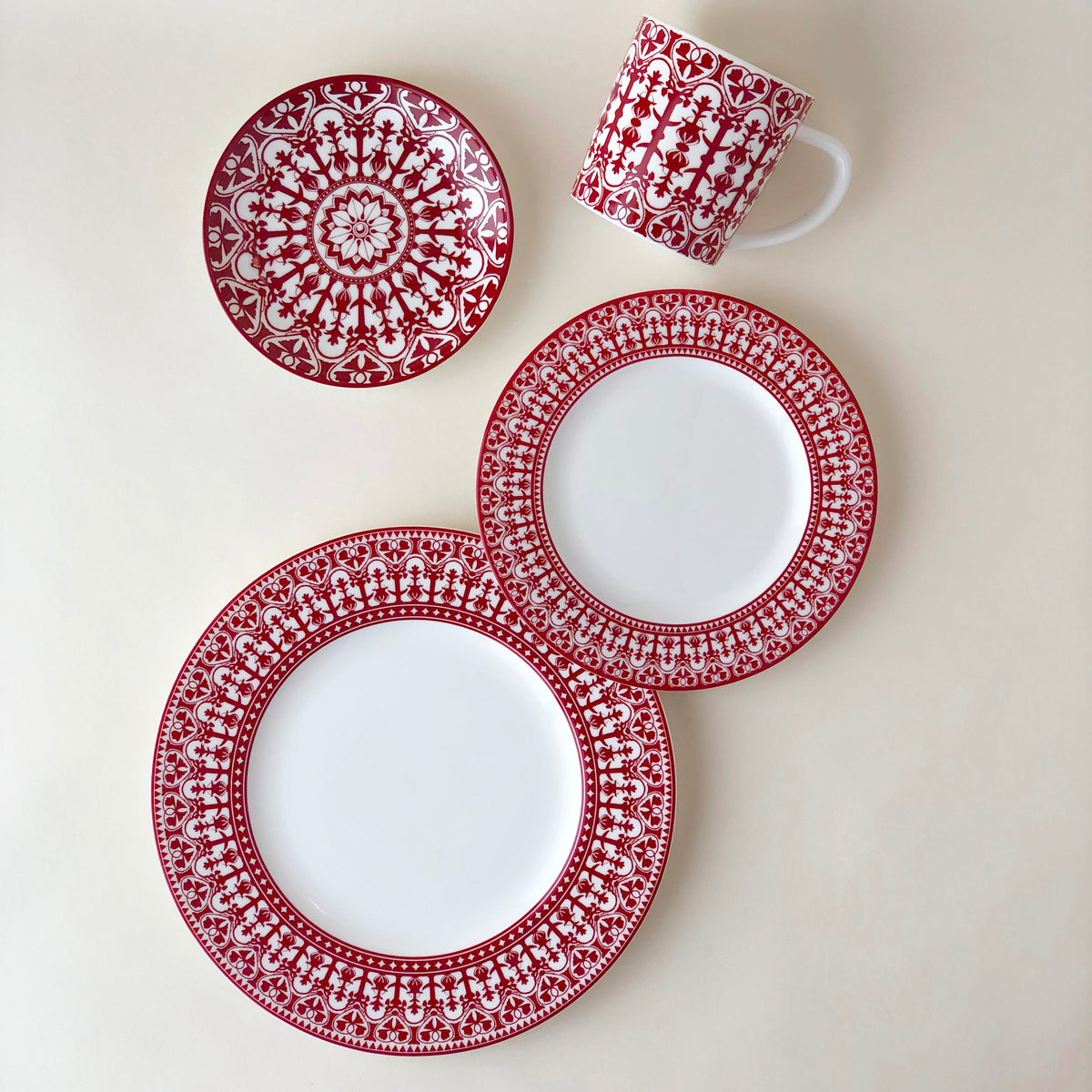 A set of Casablanca Crimson Rimmed Dinner Plates from Caskata Artisanal Home, in red and white casablanca design on a white surface.