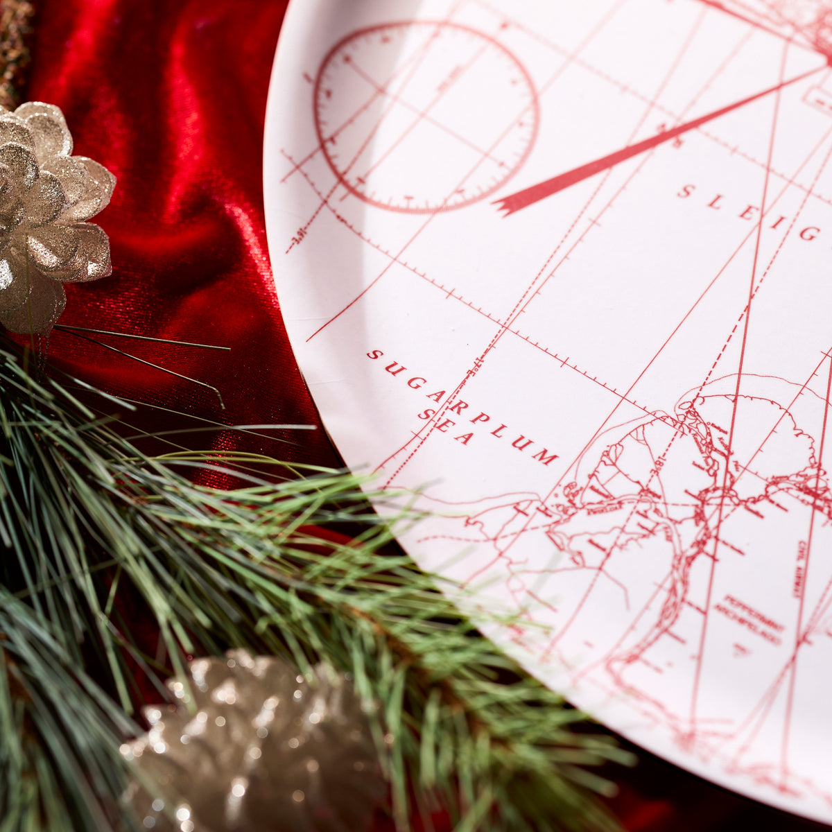 The Caskata White Holiday Hunt Large Round Tray features a red holiday design on birchwood, displayed on red velvet with pine branches and gold pinecones—perfect as a festive Christmas serving tray.