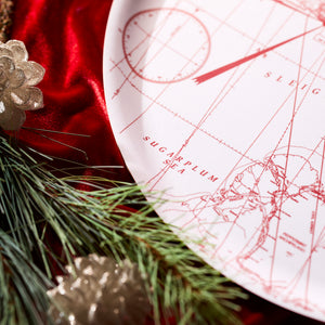 The Caskata White Holiday Hunt Large Round Tray features a red holiday design on birchwood, displayed on red velvet with pine branches and gold pinecones—perfect as a festive Christmas serving tray.