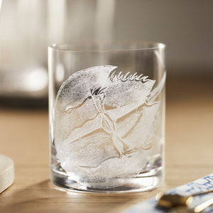 The Caskata Horseshoe Crab Rocks Glasses feature a frosted horseshoe crab design etched on clear glass with a light wooden surface.