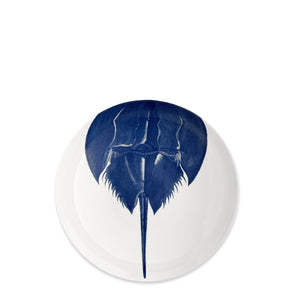 The Caskata Horseshoe Crab Entrée Bowl is a white porcelain bowl with a blue horseshoe crab illustration, inspired by New England’s coastal heritage.