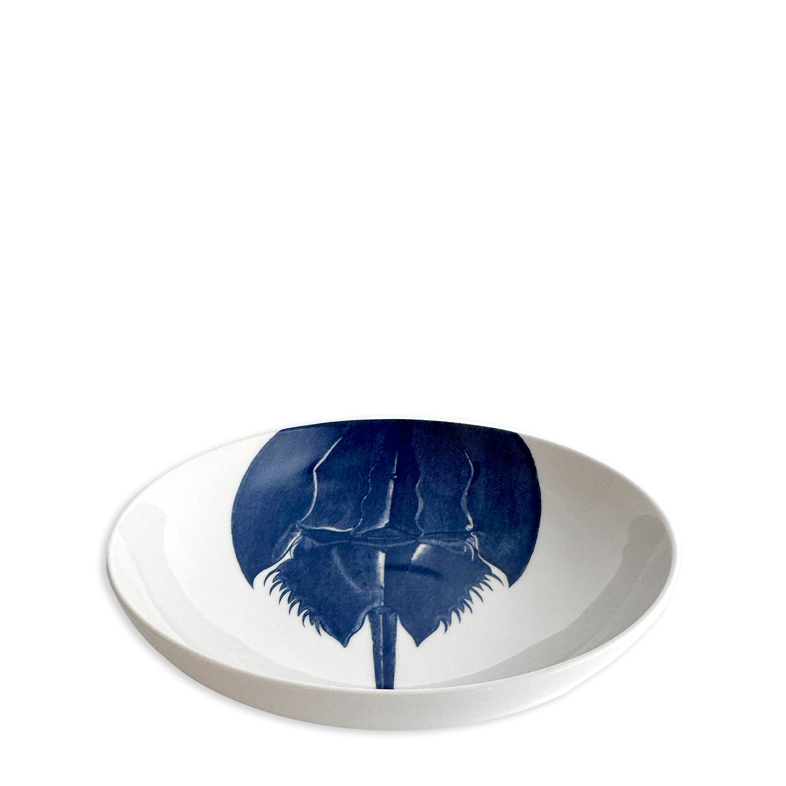 The Caskata Horseshoe Crab Entrée Bowl features a white porcelain design with a blue horseshoe crab illustration inside, making it perfect for serving soup or adding coastal charm to your New England kitchen.