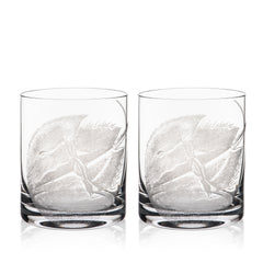 Caskata's Horseshoe Crab Rocks Glasses are two clear glass tumblers with elegant leaf designs, crafted using a sand-etching technique. These lead-free crystal pieces bring sophistication to any table.