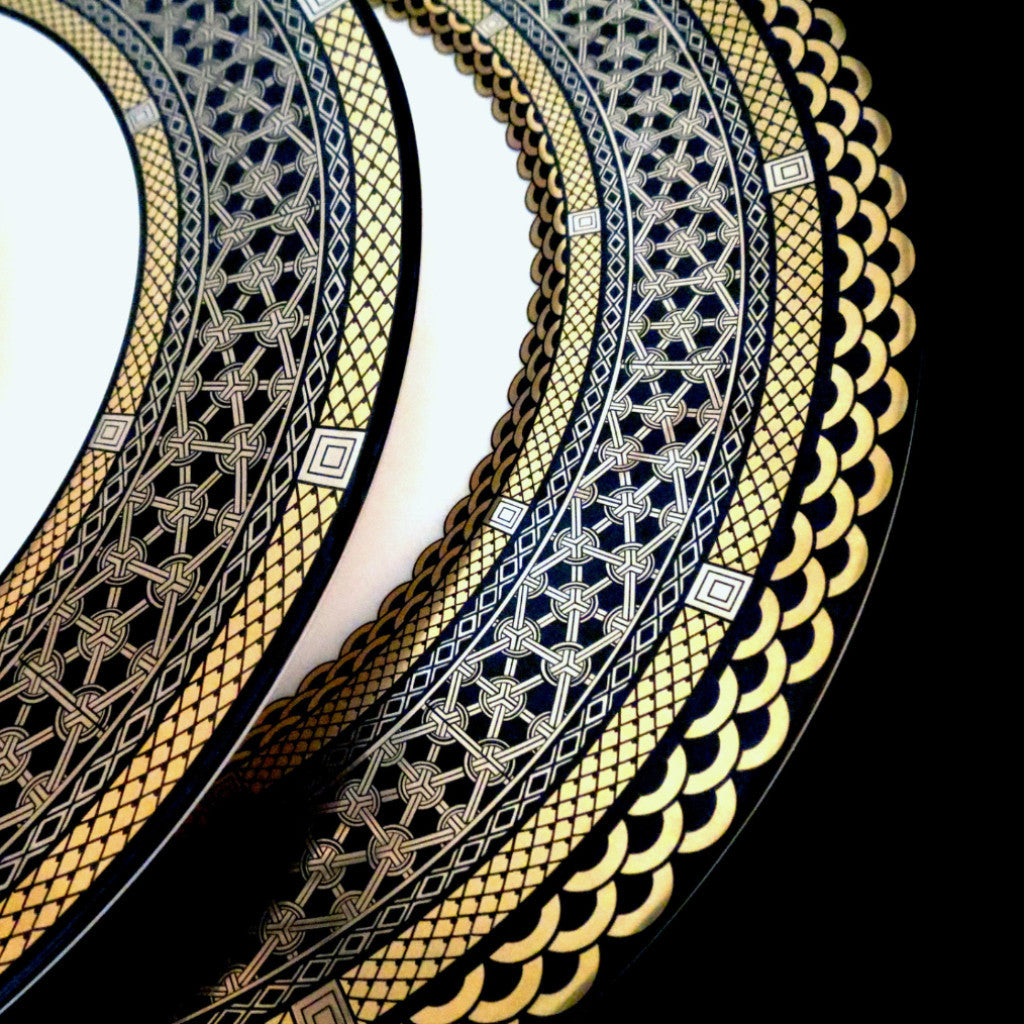 A close up of a Caskata Artisanal Home Hawthorne Onyx Gold &amp; Platinum Charger Plate.