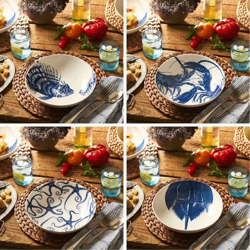 The Caskata Coastal Icons Entrée Bowls, Mixed Set of 4, features white bowls with blue marine life designs—horseshoe crab, brittle stars, lionfish, and lobster—bringing seaside charm to your table.