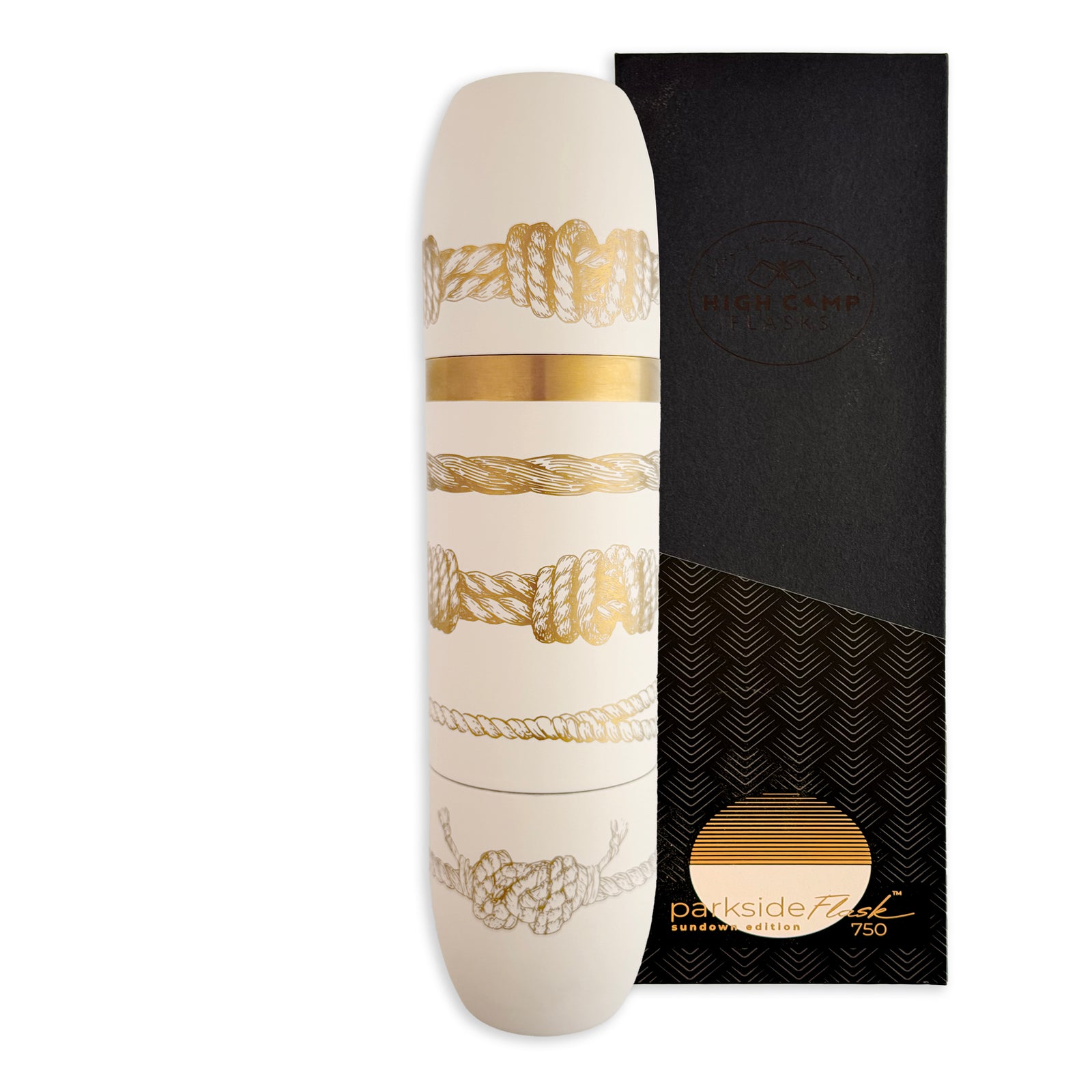 The Caskata x High Camp Crema Sailors Knots Wine Flask, featuring gold and silver knot designs, stands beside its black and gold "High Camp Parksider Flask 750" box, adding nautical flair to your drinkware collection.