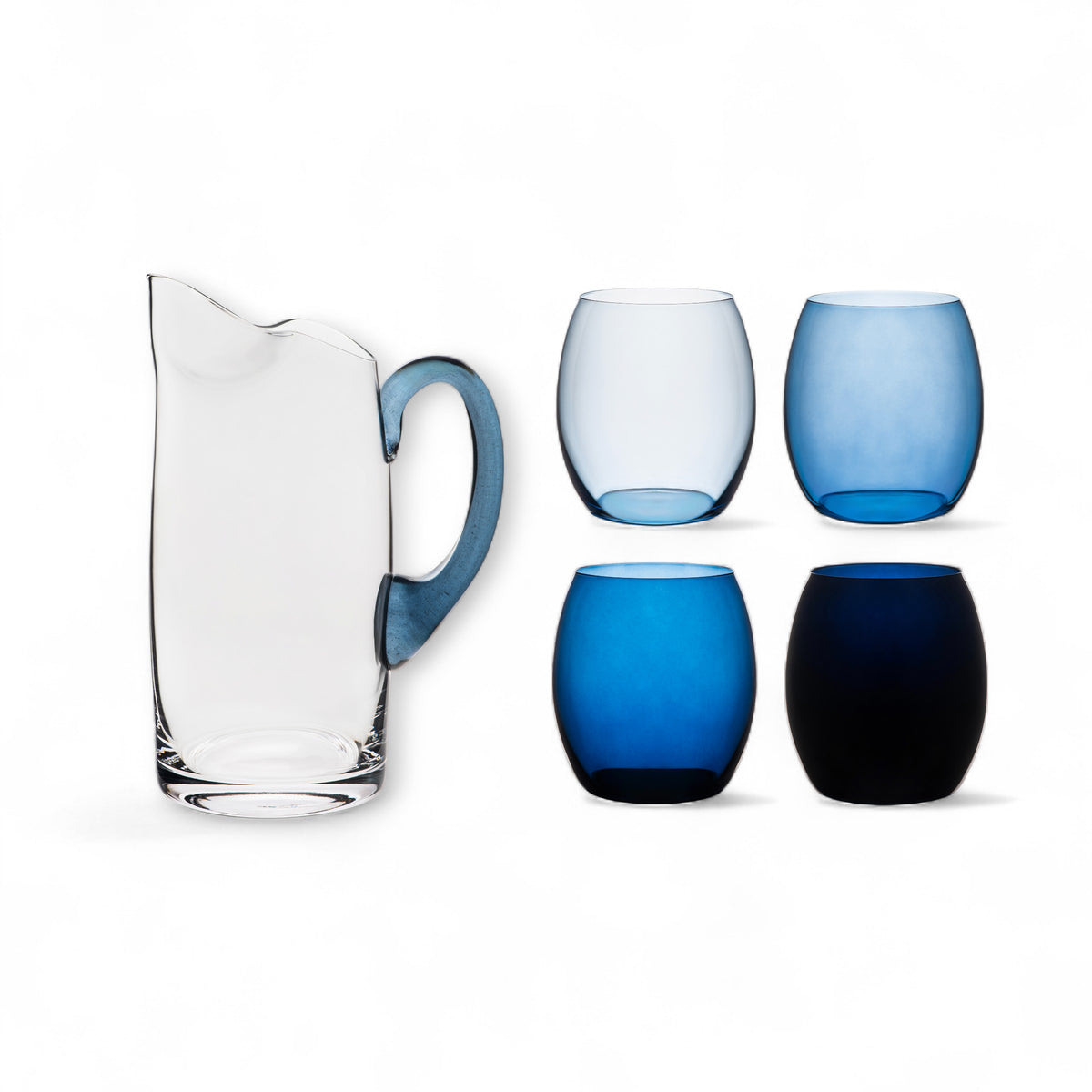 The Santorini Set" Bundle by Caskata features a clear glass pitcher with a blue handle alongside four Les Nuages Tumblers in assorted blue shades, all displayed on a white background.
