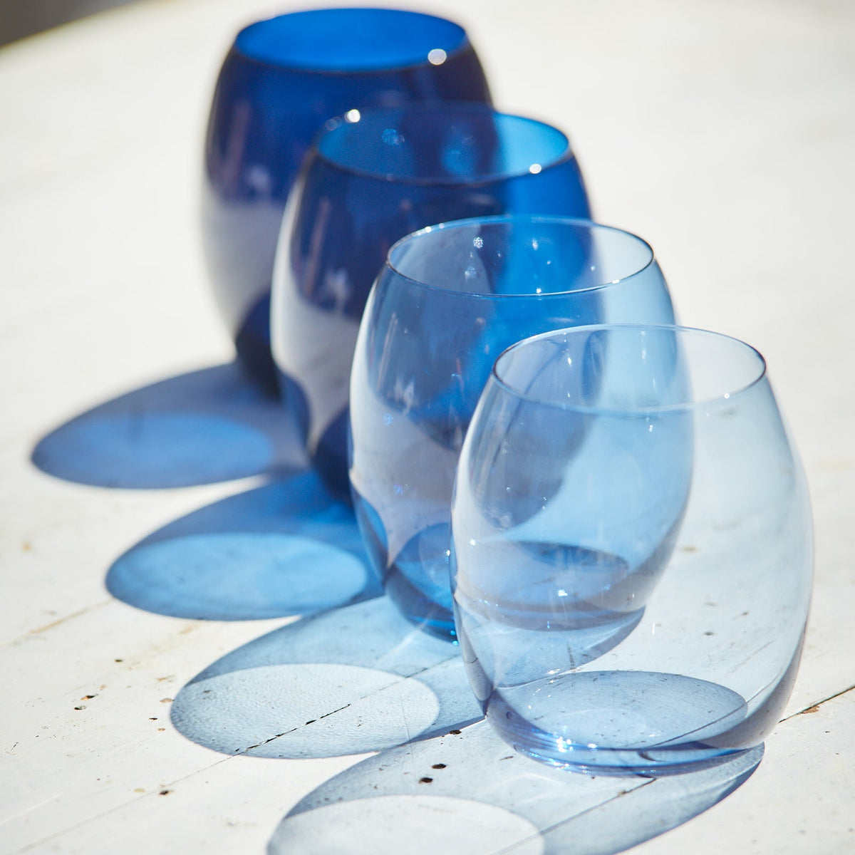 Three Les Nuages Blue Ombré Glasses Set of 4 by Caskata sitting on a table.