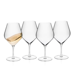 Caskata Library White Wine Glasses, Set of 4, crafted from lead-free crystal, are shown on a white background; one glass holds a little wine, while the other three are empty.