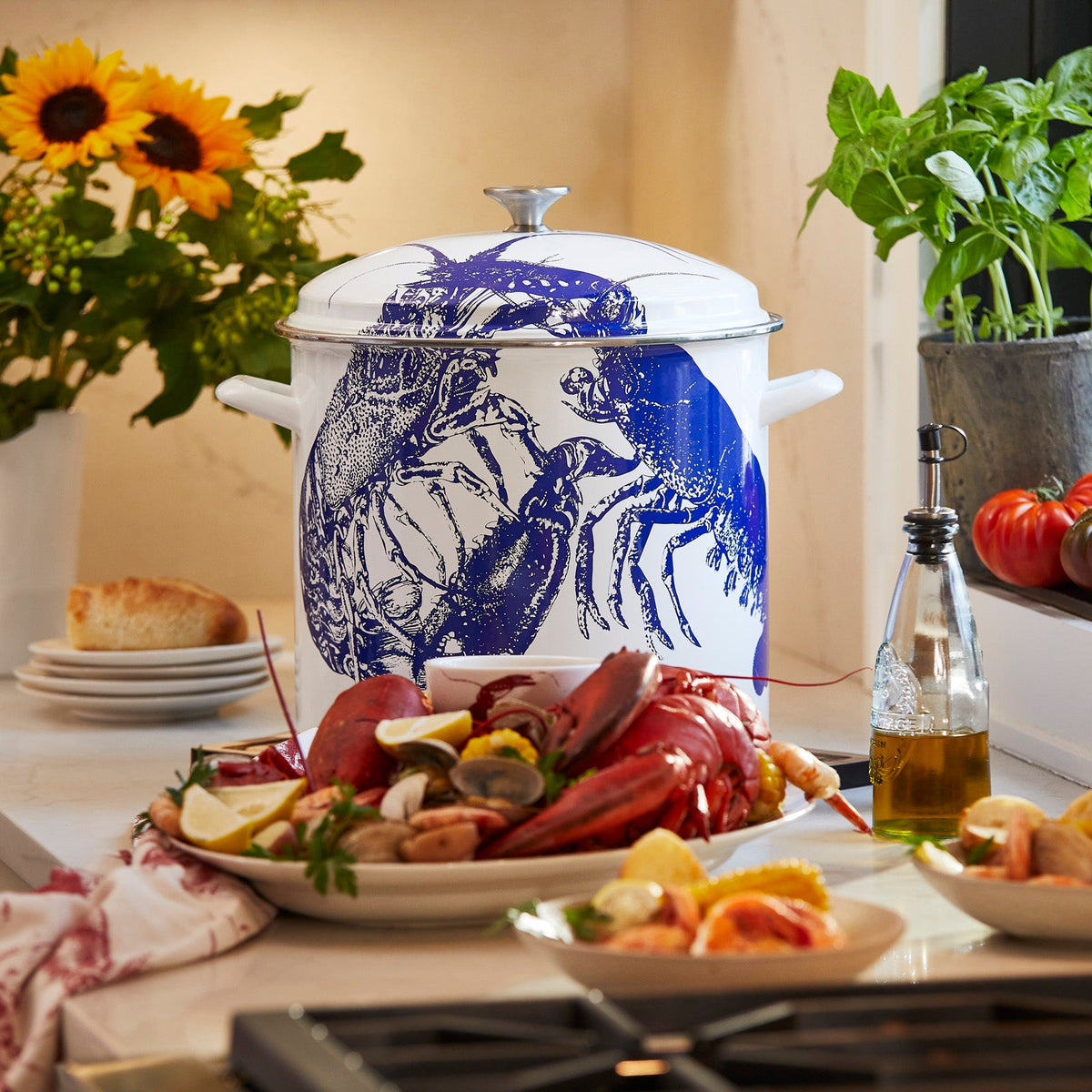 A Caskata X Cuisinart Limited Edition Lobster 16 Qt. Enamel on Steel Stockpot, perfect for clambakes, rests on a kitchen counter.
