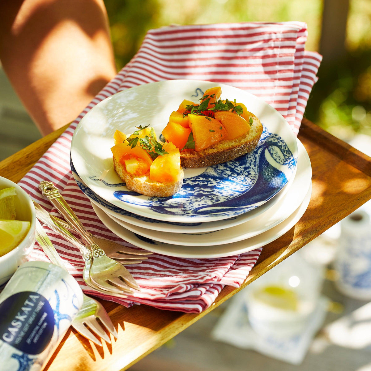 A hors-d&#39;oeuvres tray featuring Lucy Canapé plates and red and white stripe napkins by Caskata.