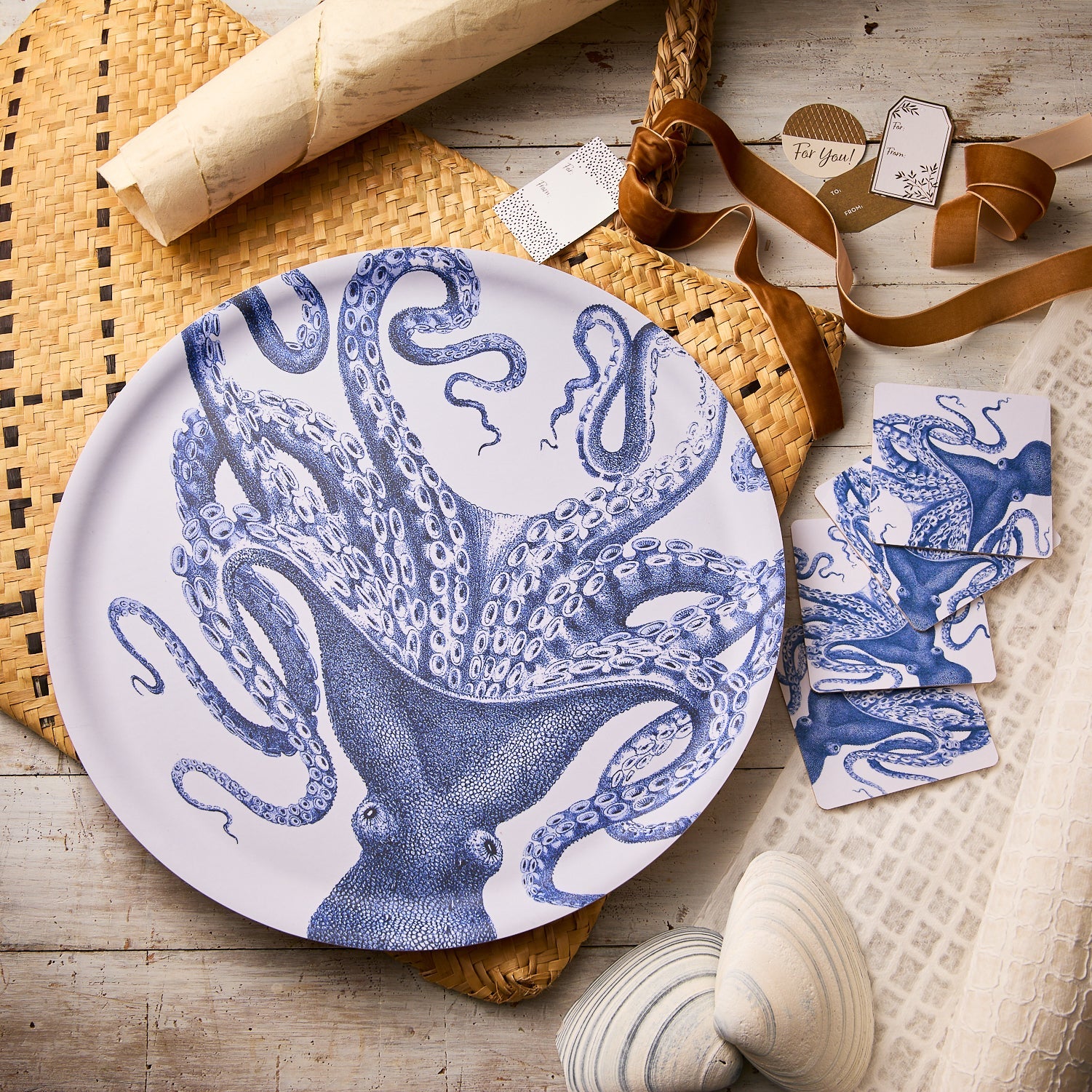 The Caskata Lucy for the Win Bundle features a ceramic plate and matching octopus-themed coasters, beautifully displayed with seashells and festive accents—making it the ideal entertaining gift for any ocean lover.