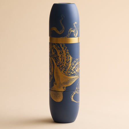 Caskata x High Camp Dark Blue Lucy Wine Flask in a cylindrical shape, decorated with a gold octopus illustration.