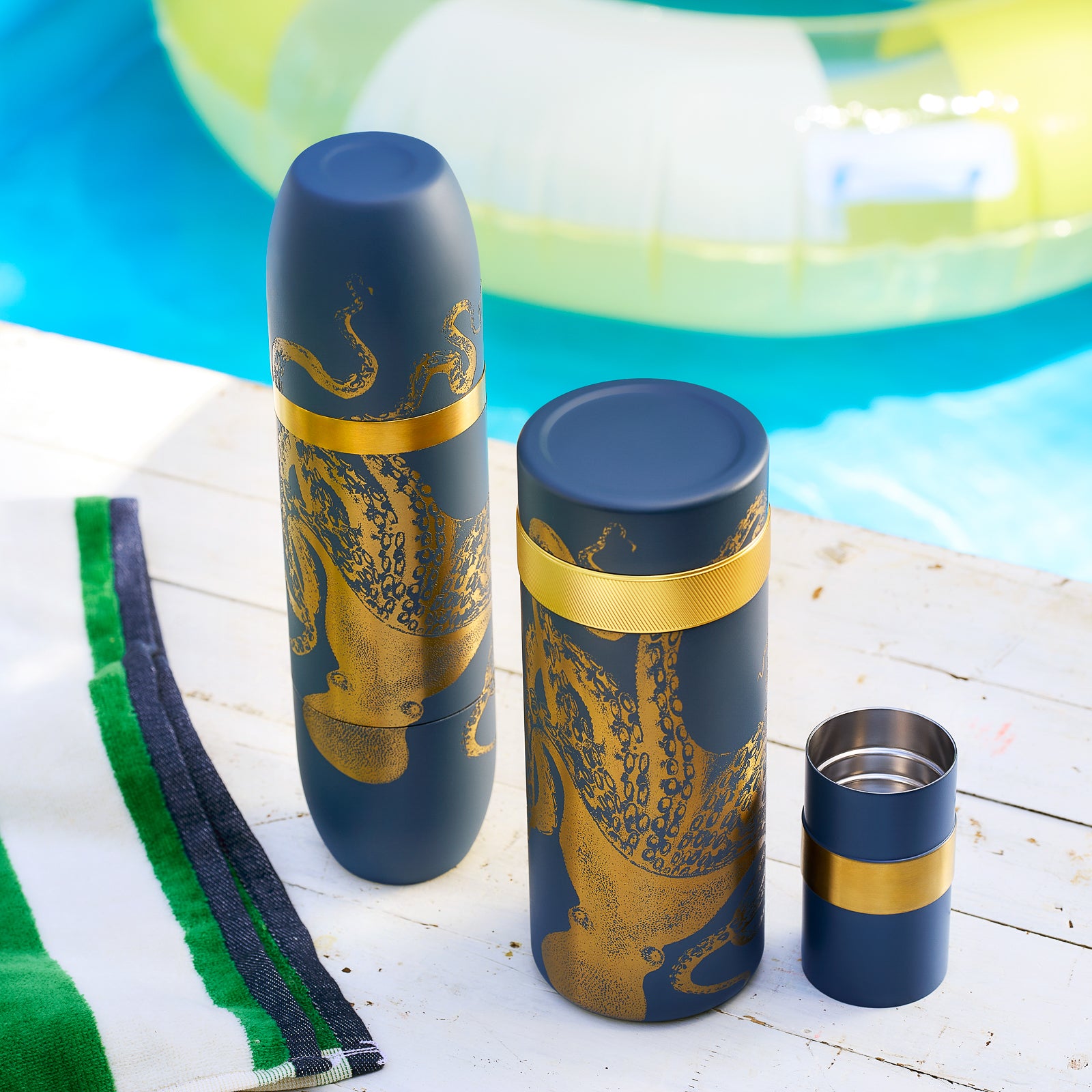 The Caskata X High Camp Flasks Lucy Wine and Cocktail Bundle features three dark cylindrical containers with gold octopus motifs and bands—an elegant addition to any barware set, exclusively from Caskata.