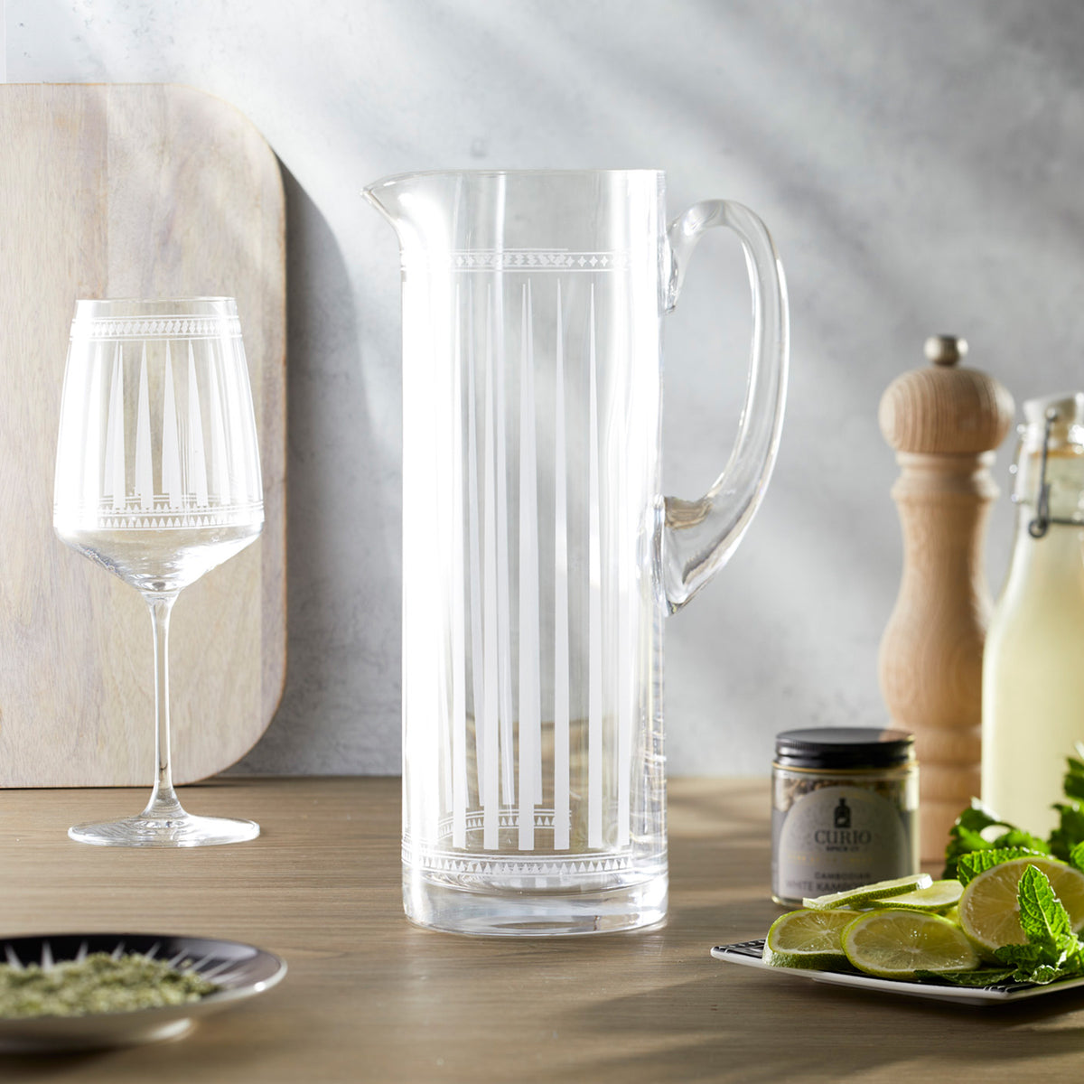 An elegant Marrakech Tall Pitcher with a lime, perfect for serving drinks in lead-free crystal from Caskata Artisanal Home.