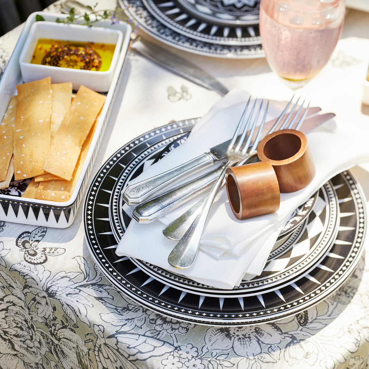 A black and white tablecloth with Dot and Army&#39;s Round Wooden Napkin Rings Set/4.