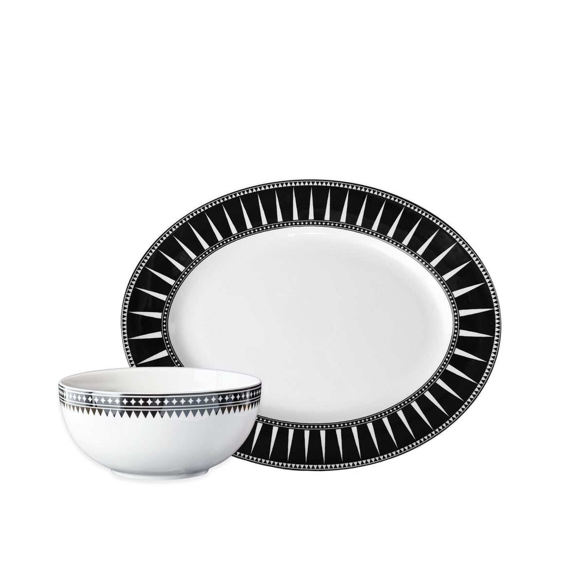 The Caskata Marrakech Serving Set features a white porcelain plate and bowl with black geometric rim patterns, inspired by Art Deco serveware, shown against a plain white background.