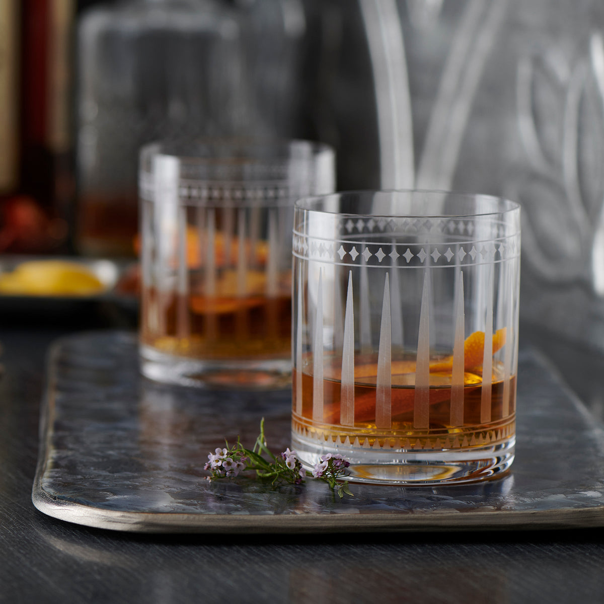 A stylish Marrakech Cocktail Collection set with two glasses of whiskey on a tray from Caskata Artisanal Home.