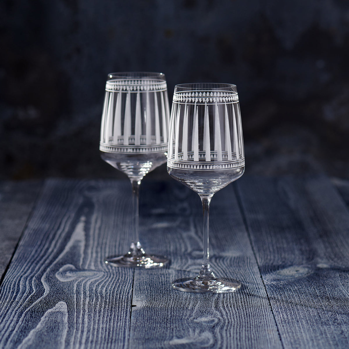 Two elegant Marrakech White Wine Glasses by Caskata Artisanal Home on a wooden table.