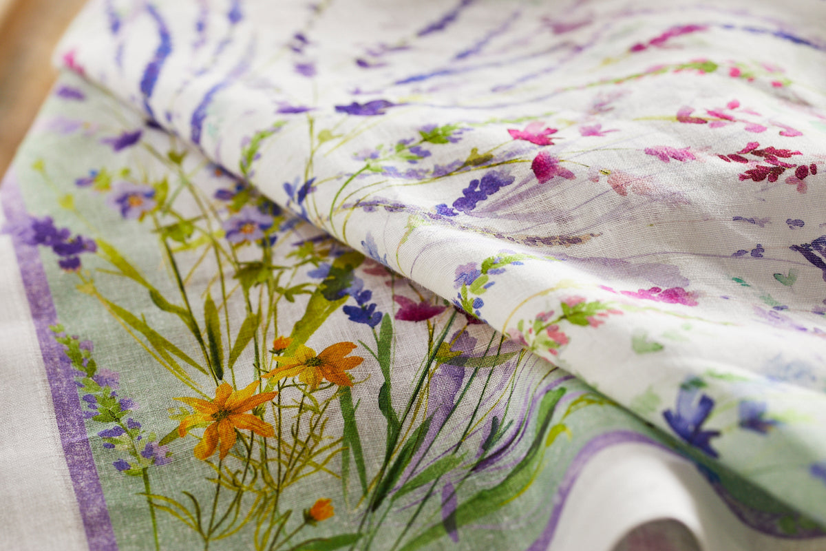 A close up of the TTT Meadow Linen Table Runner featuring delicate wildflowers.