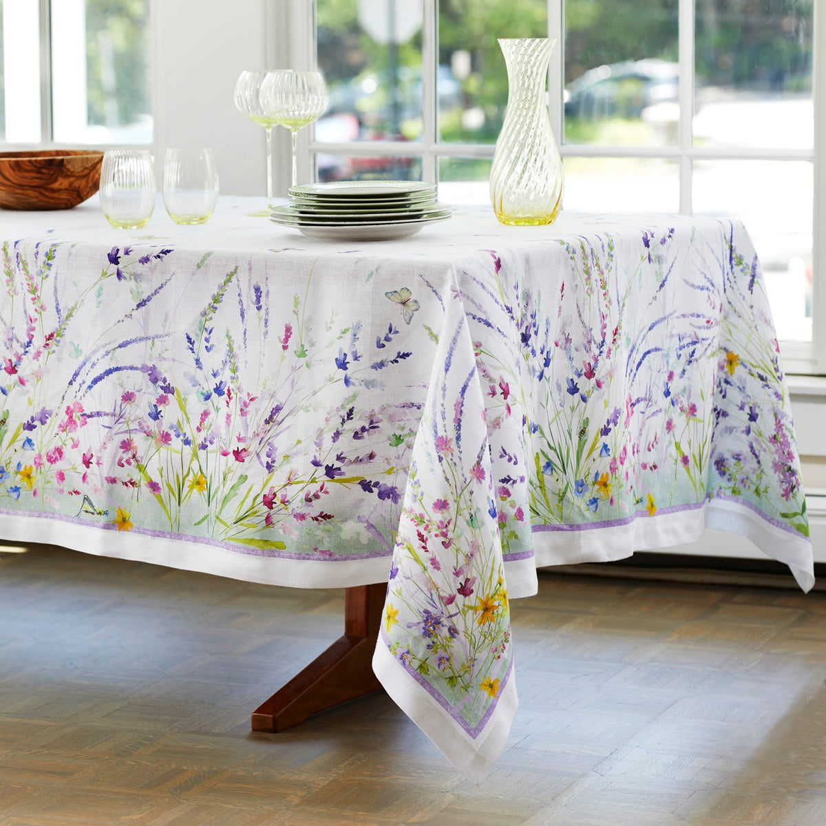 Meadow Tablecloth in 67&quot; x 106&quot; size features hand-painted floral watercolors in shades of blue, purple and green on Italian linen, from Caskata