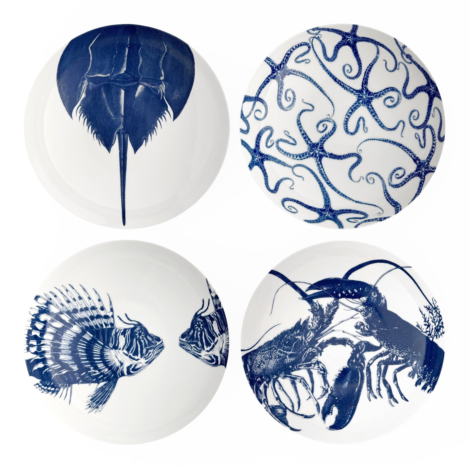 The Caskata Coastal Icons Entrée Bowls, Mixed Set of 4, features white bowls with blue marine life designs—horseshoe crab, brittle stars, lionfish, and lobster—bringing seaside charm to your table.
