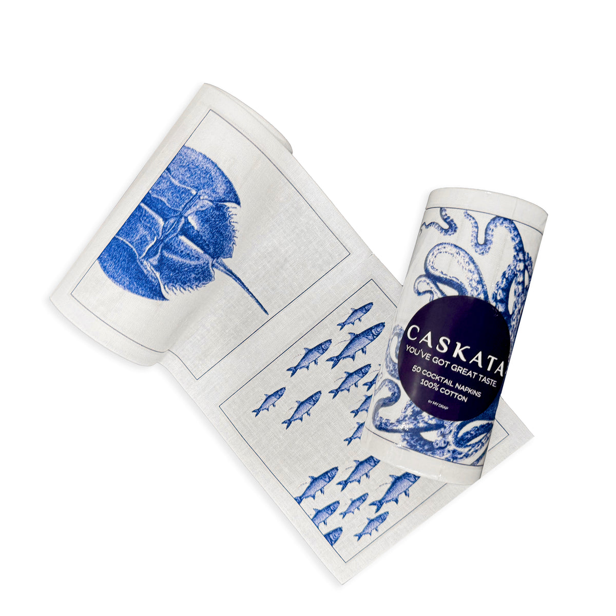 A rolled-up kitchen towel with blue sea creature designs on a white background, partially unrolled to display images of fish, a shell, and an octopus. The label reads &quot;MY DRAP.&quot; This Coastal Cocktail Napkin Roll makes the perfect beach-lover&#39;s gift.