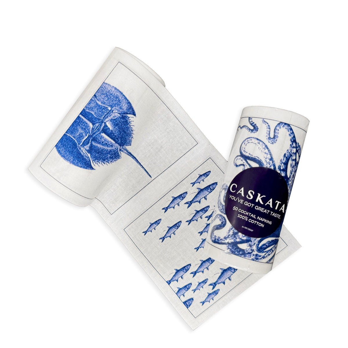 A rolled-up kitchen towel with blue sea creature designs on a white background, partially unrolled to display images of fish, a shell, and an octopus. The label reads "MY DRAP." This Coastal Cocktail Napkin Roll makes the perfect beach-lover's gift.