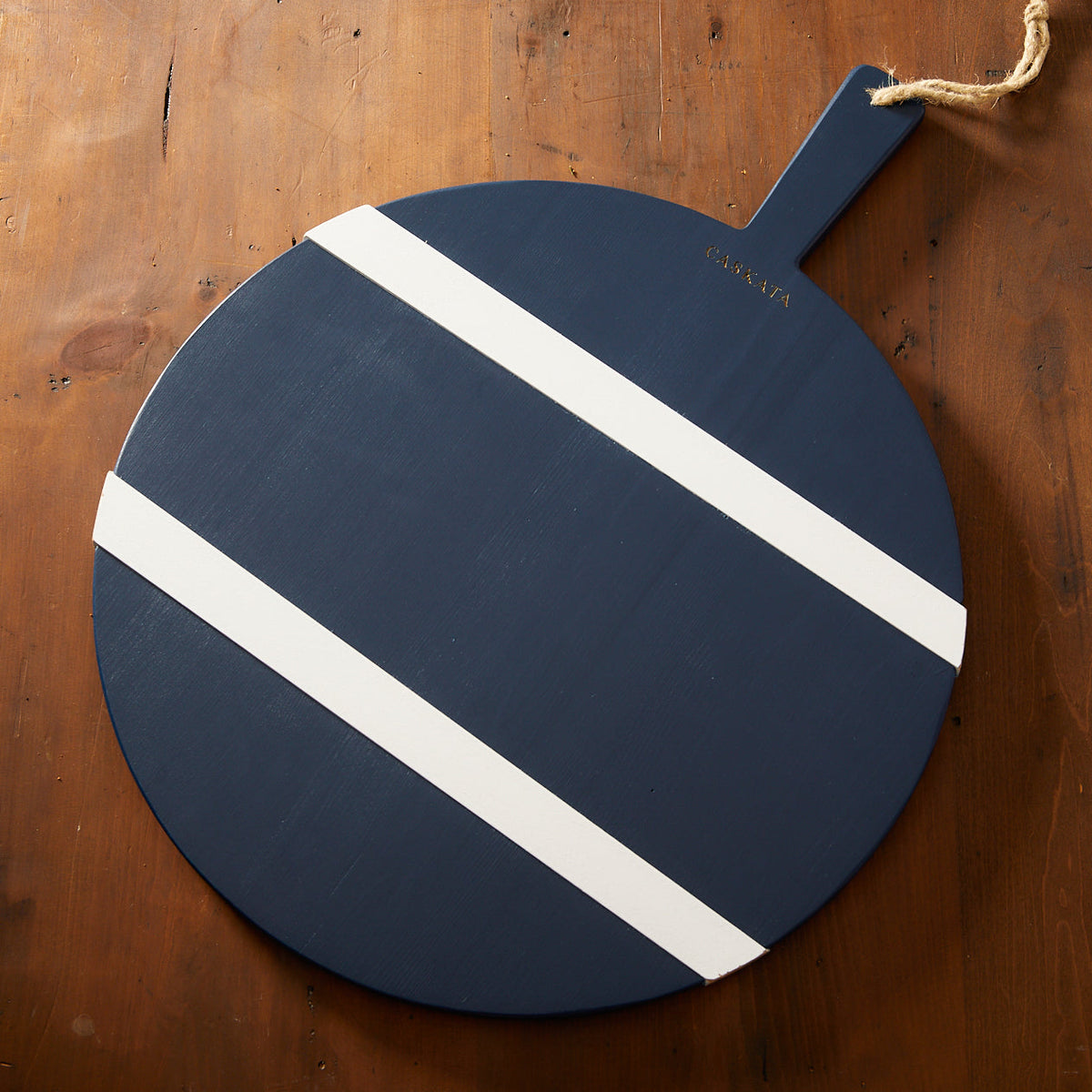 A big Navy and White Round Charcuterie Big Board with a wood grain pattern on a wooden table, perfect for holiday entertaining.