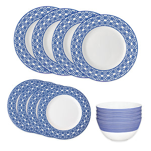 The Newport Garden Gate Table for 4 by Caskata is an elegant porcelain dinnerware set, featuring six dinner plates and six salad plates with blue geometric rims, plus stacked bowls adorned with horizontal blue stripes.
