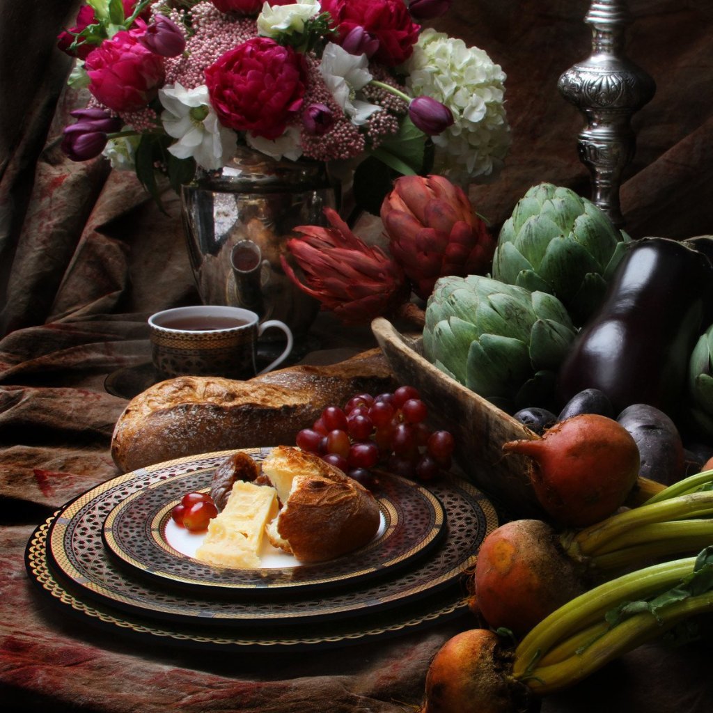 A plate of Hawthorne Onyx Gold &amp; Platinum 5-Piece Place Setting by Caskata Artisanal Home and flowers on a table, showcasing the perfect blend of culinary delight and natural beauty.