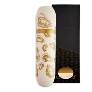 The Caskata x High Camp Crema Oysters Wine Flask features a white insulated design with a gold oyster shell motif, displayed next to its elegant black and gold packaging, echoing the sophistication of fine wine bottles.
