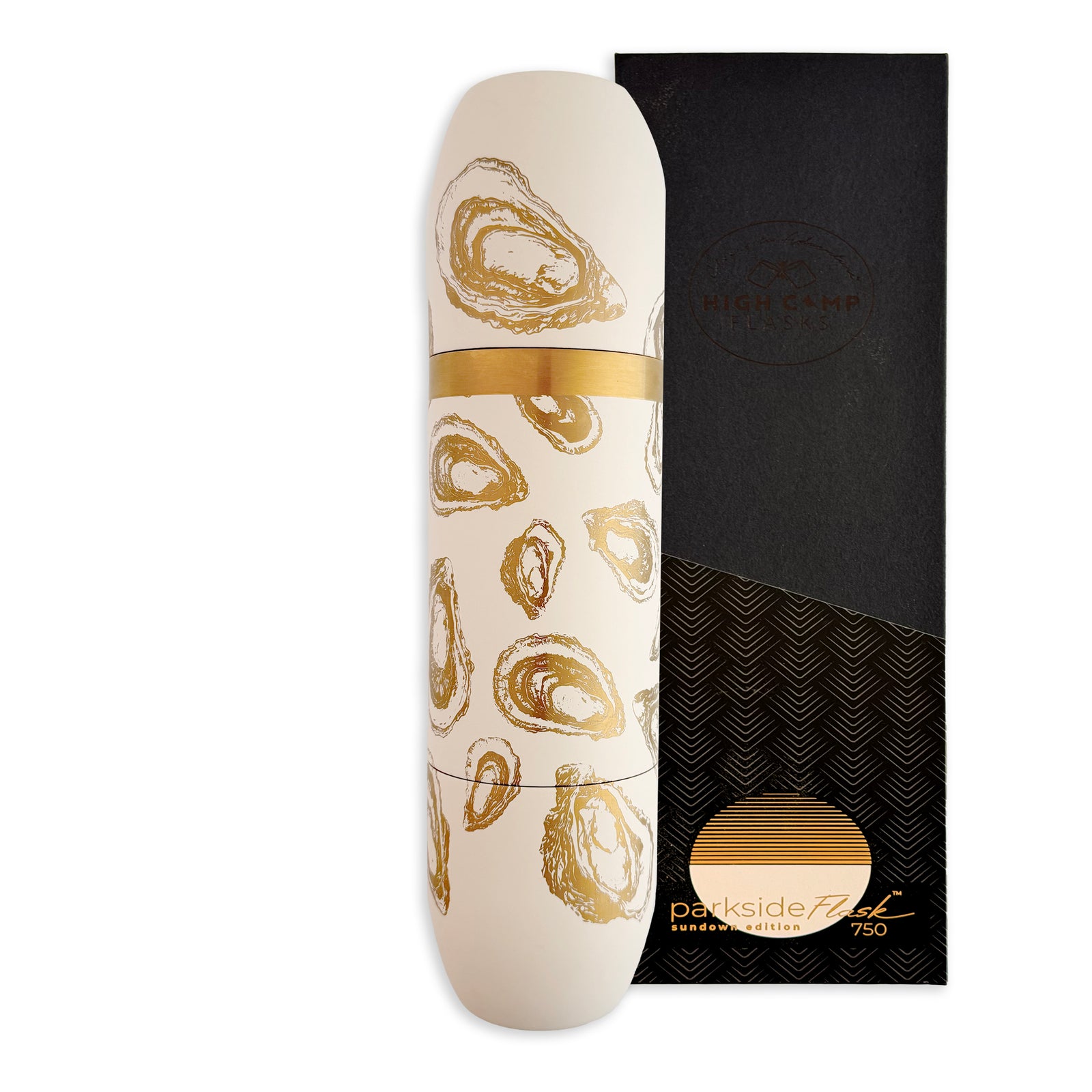 The Caskata x High Camp Crema Oysters Wine Flask features a white insulated design with a gold oyster shell motif, displayed next to its elegant black and gold packaging, echoing the sophistication of fine wine bottles.
