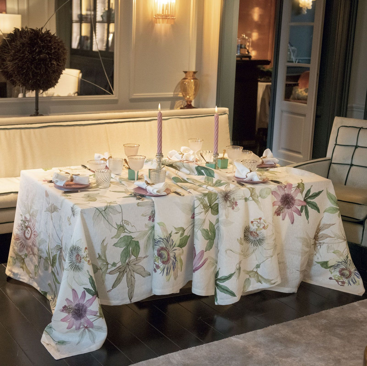 A dining room table with a Passionflower Linen Tablecloth adorned with passionflowers by TTT.