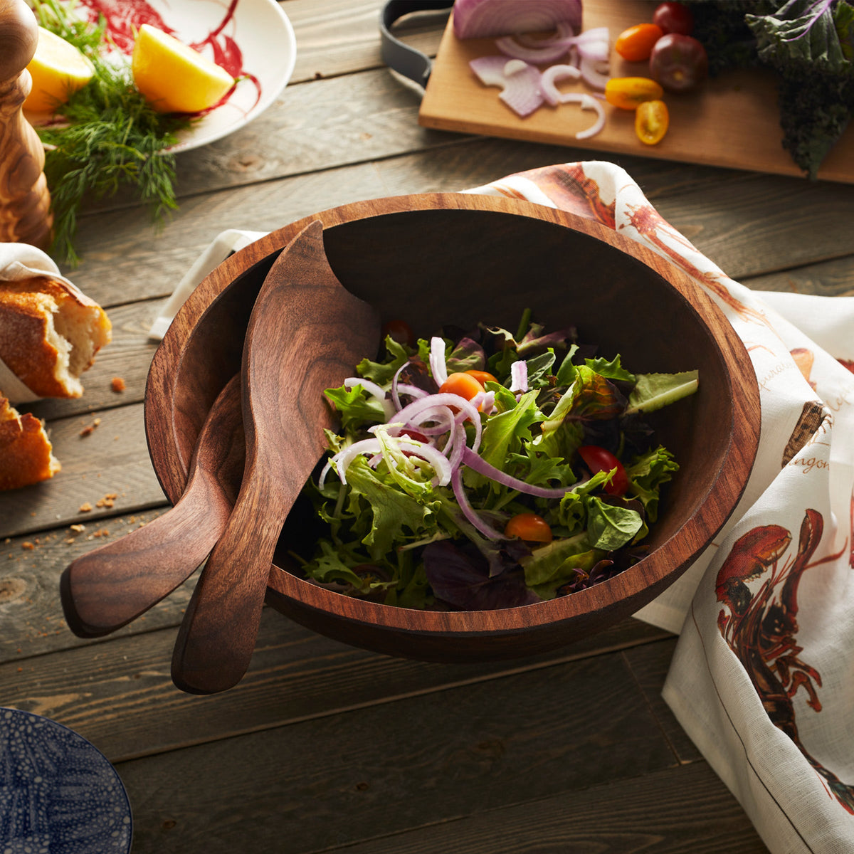 A Peterman&#39;s black walnut wooden bowl with a salad in it.