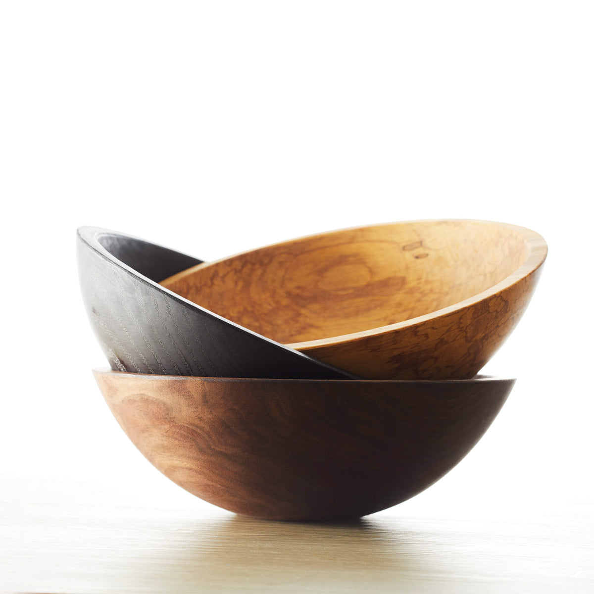 Three Spalted Maple 13&quot; Handcrafted Serving Bowls, crafted by an artisan woodworker, sitting on top of a table made from exquisite Maple wood, all brought to you by Peterman&#39;s.