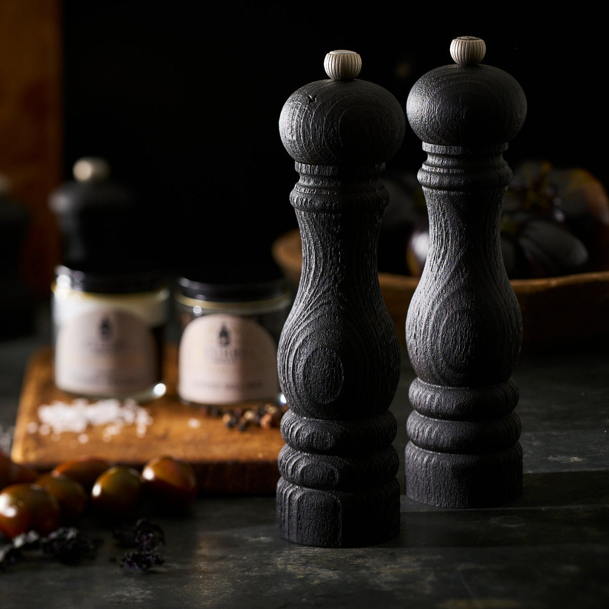 Two eco-friendly Peugeot Paris 9&quot; Black Salt &amp; Pepper Mill Sets made from recycled beech wood on a cutting board.