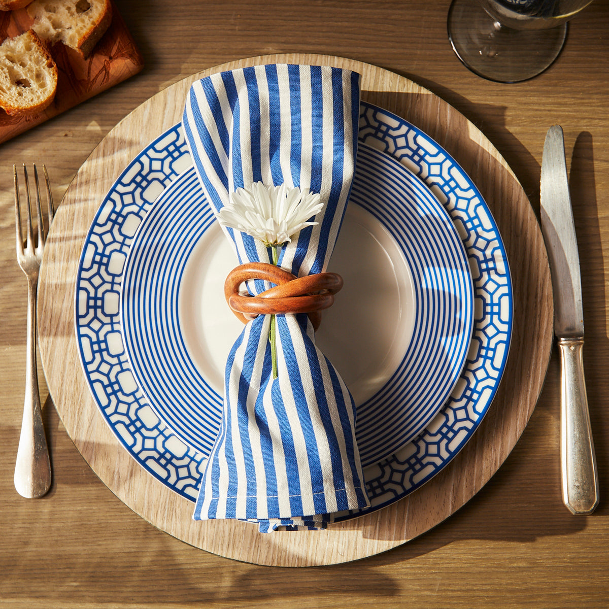 A Caskata Pinstripe Dinner Napkins in Blue Set/4 with a flower on it.