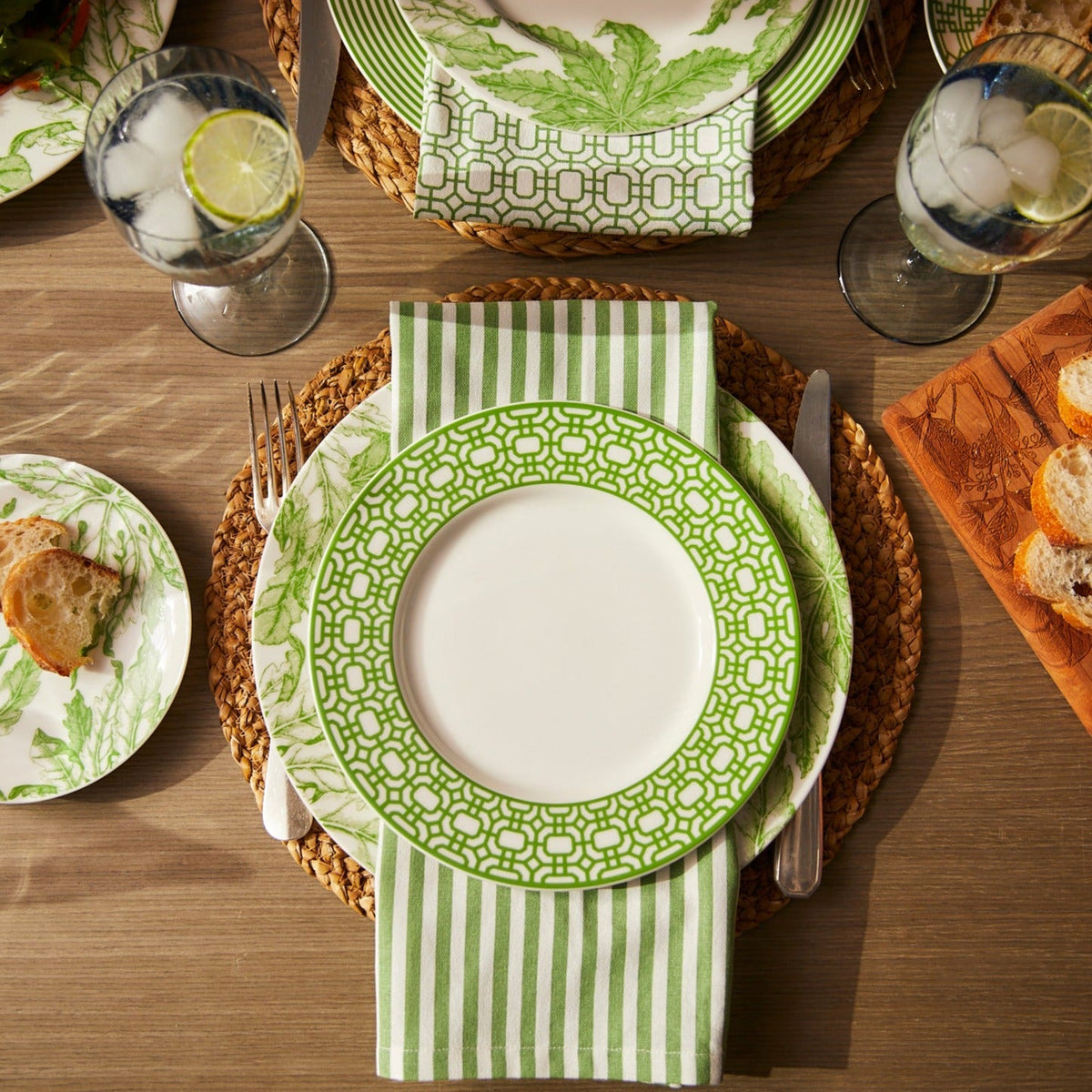A table setting with Caskata Pinstripe Dinner Napkins in Green Set/4.