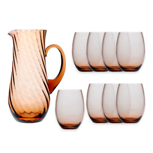 The Quinn Amber Sangria Set by Caskata features a brown glass pitcher with handle and eight matching spiral-textured tumblers, showcasing the classic elegance of Czech glassware.