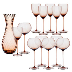 The Quinn Amber Wine Lovers Set by Caskata features twelve amber crystal wine glasses and a matching patterned carafe, elegantly displayed on a white background.