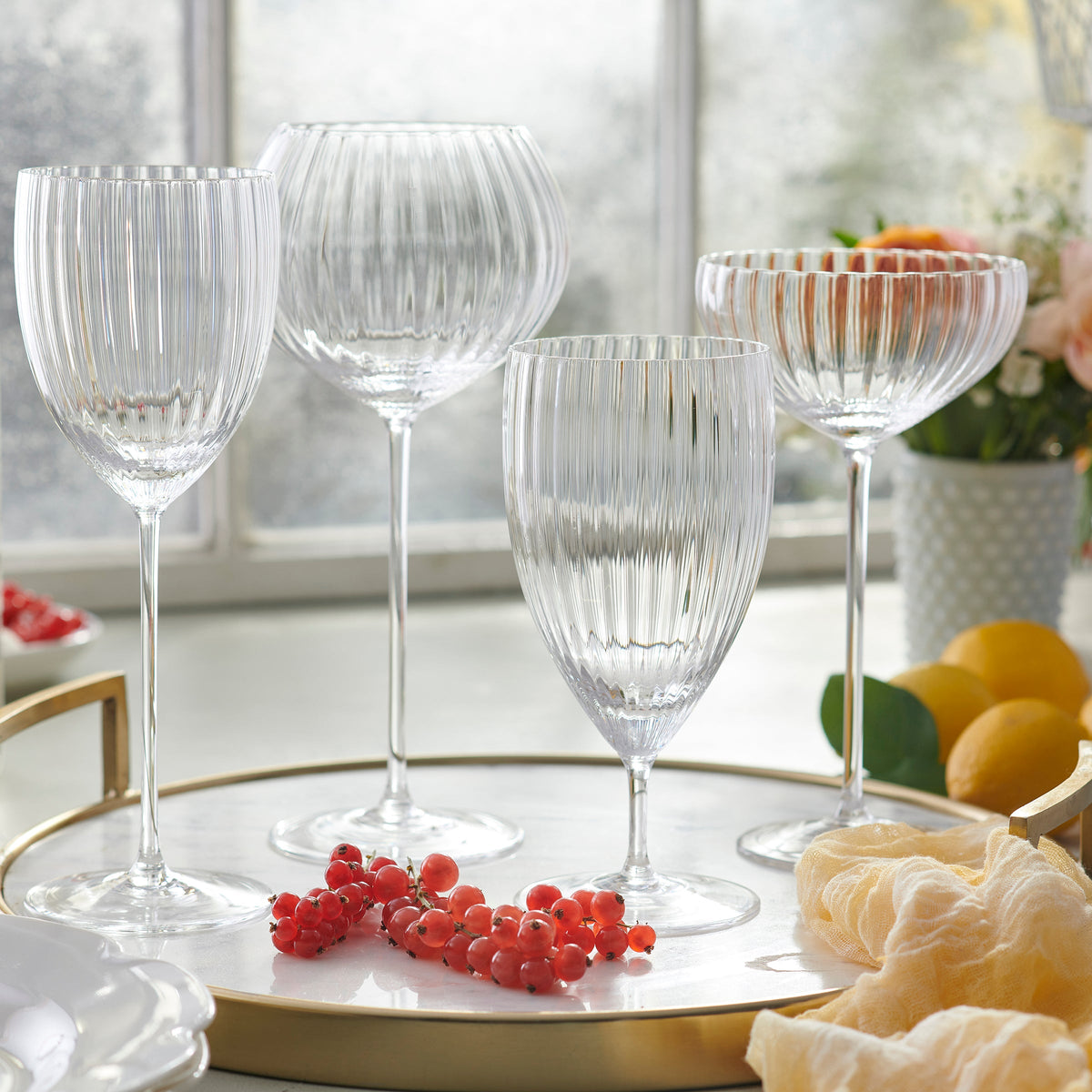 A set of Quinn Clear White Wine Glasses by Caskata Artisanal Home on a tray.