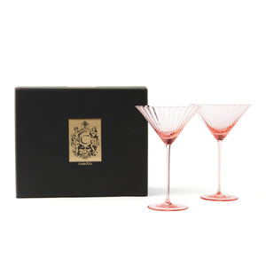 The Caskata Cheers to You Bundle features two pink crystal martini glasses beside a box, perfect as a stylish hostess gift.