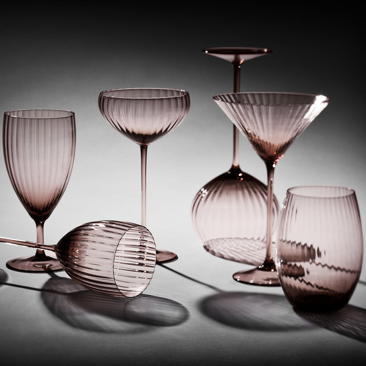 The Quinn Mocha mouth blown crystal collection by Caskata includes everyday, white wine, coupe, red wine, martini, and tumbler glasses.