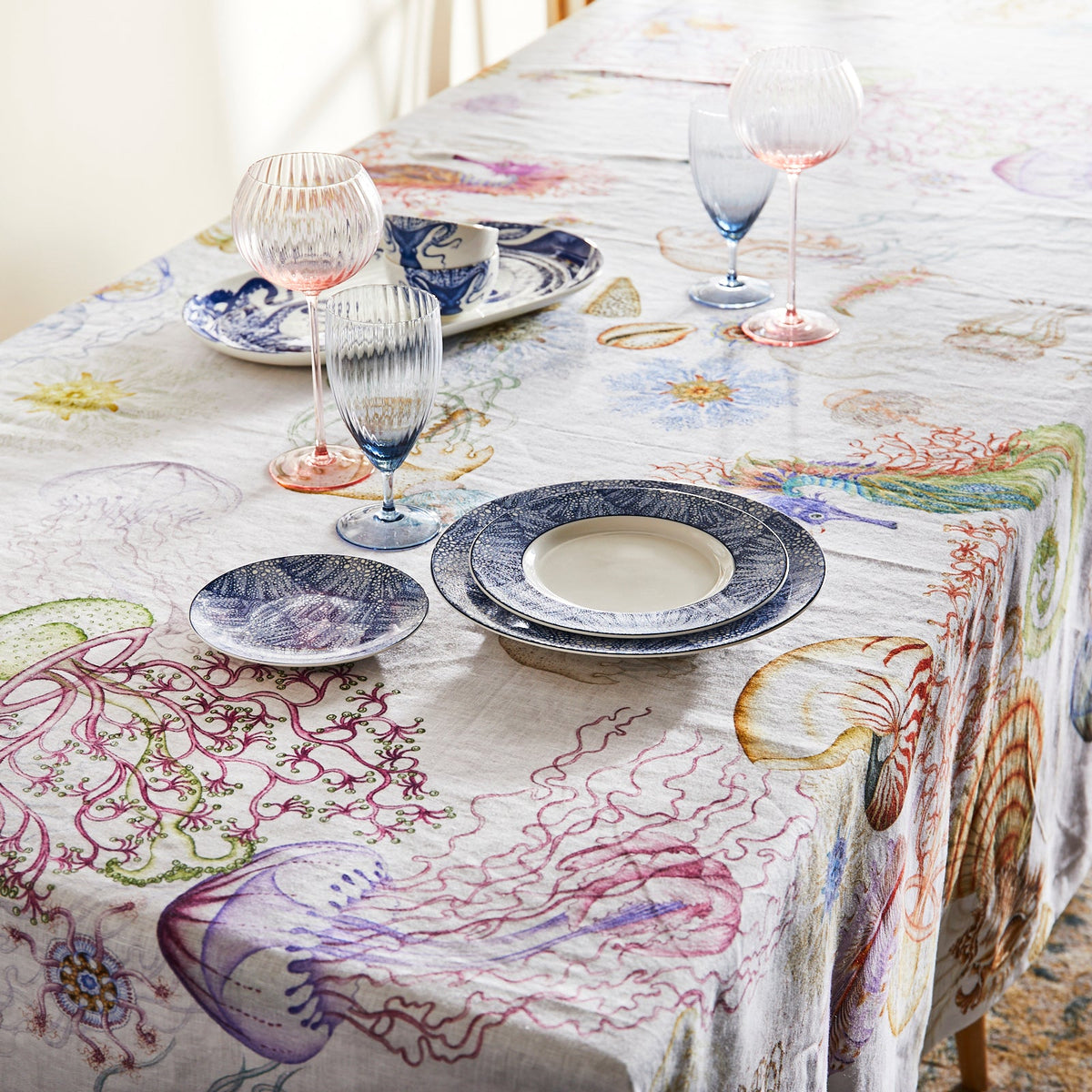 A Dining Table Set with Reef Linen Tablecloth featuring watercolor Shells, Jellyfish, Coral, Seahorses from Caskata